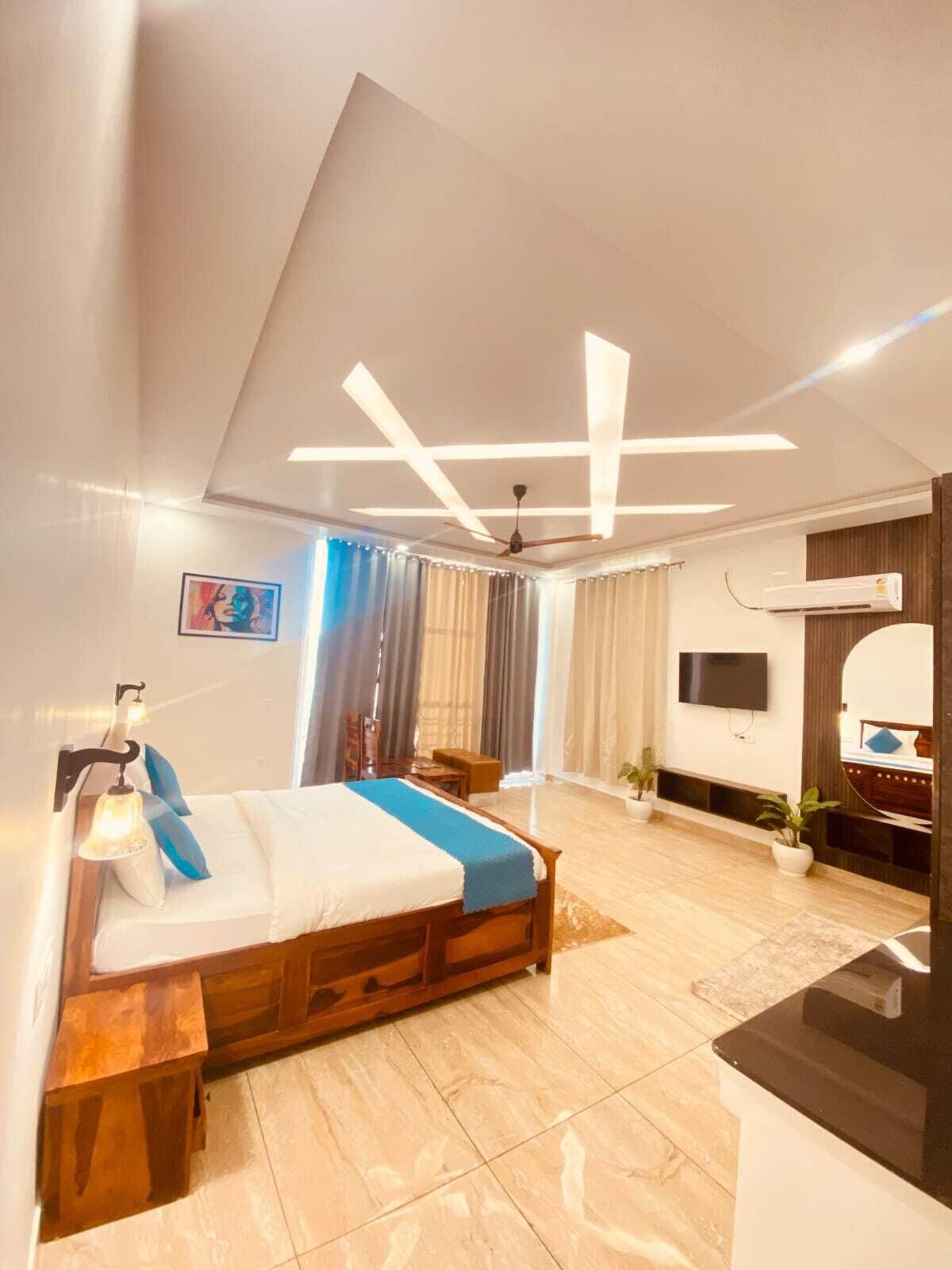A modern hotel room with a bed, bedside tables, a desk, a TV, and a ceiling fan.