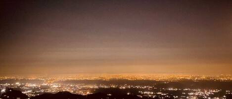 A nighttime cityscape with a view of the city lights from a high vantage point.