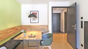 Un moderno comedor con una mesa de madera, un jarrón con flores y un frutero.