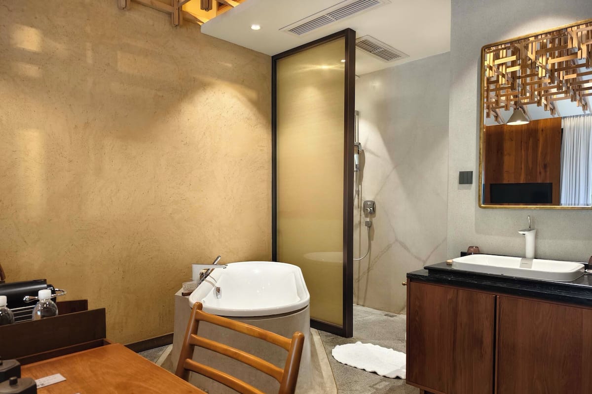 A modern bathroom with a bathtub, a sink, and a wooden vanity.