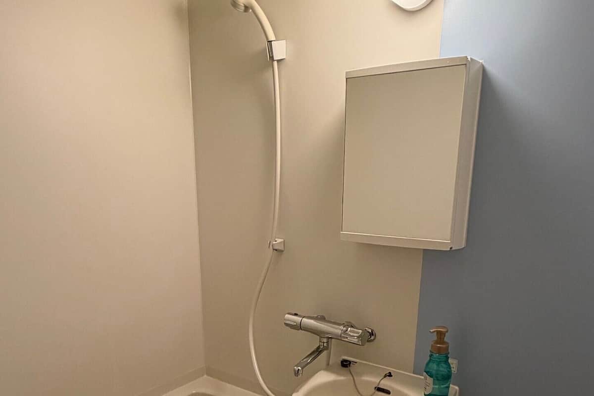 A bathroom with a bathtub, a sink, and a shower head.