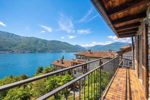 Uma varanda com vista para um lago e montanhas.