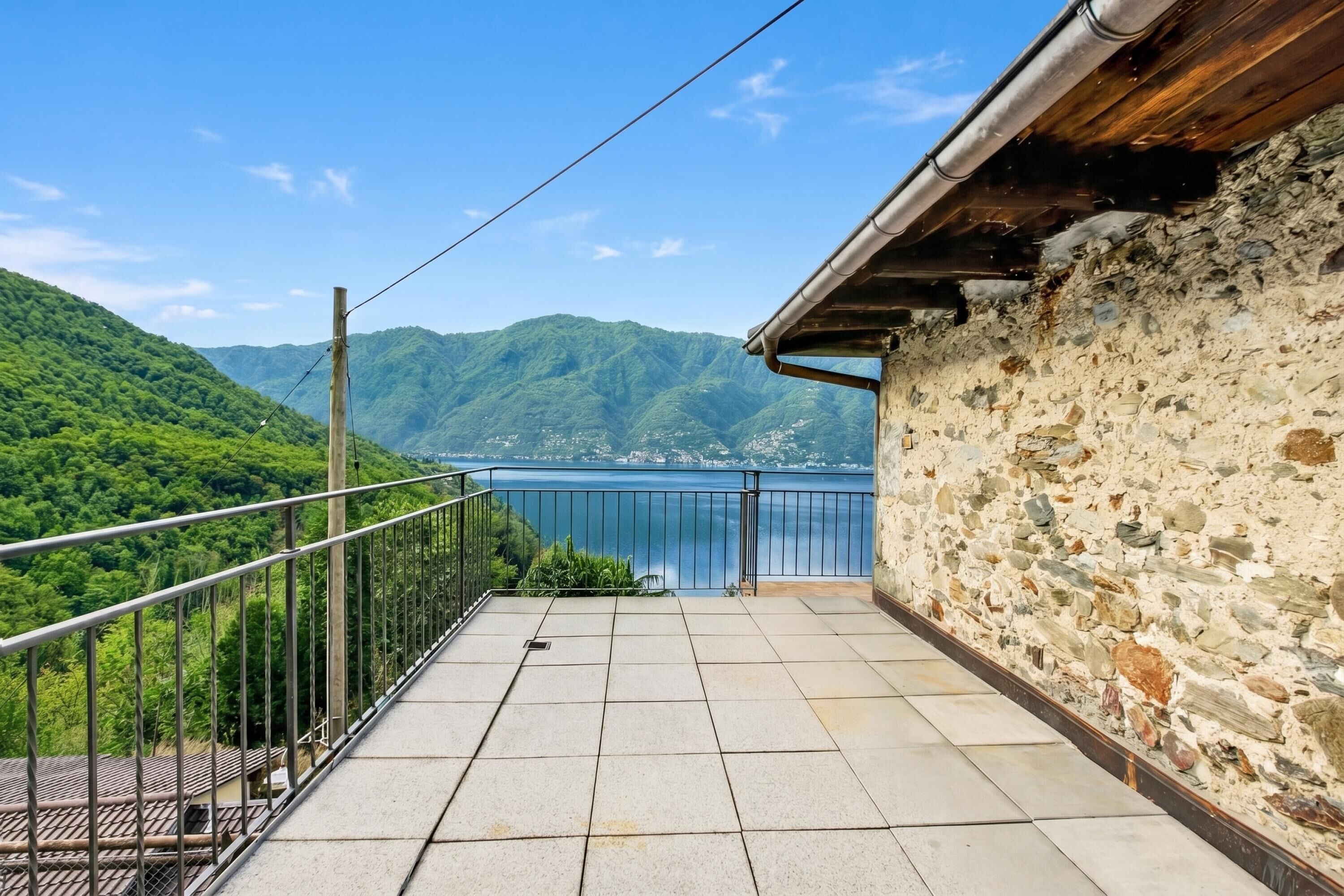 Un balcone con vista su un lago e montagne.