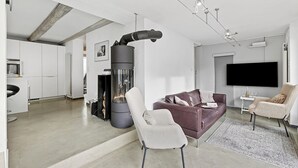 A modern living room with a fireplace, a sofa, a chair, and a TV. - Casa la Tortue 2 Scaiano for 6 (Gambarogno)