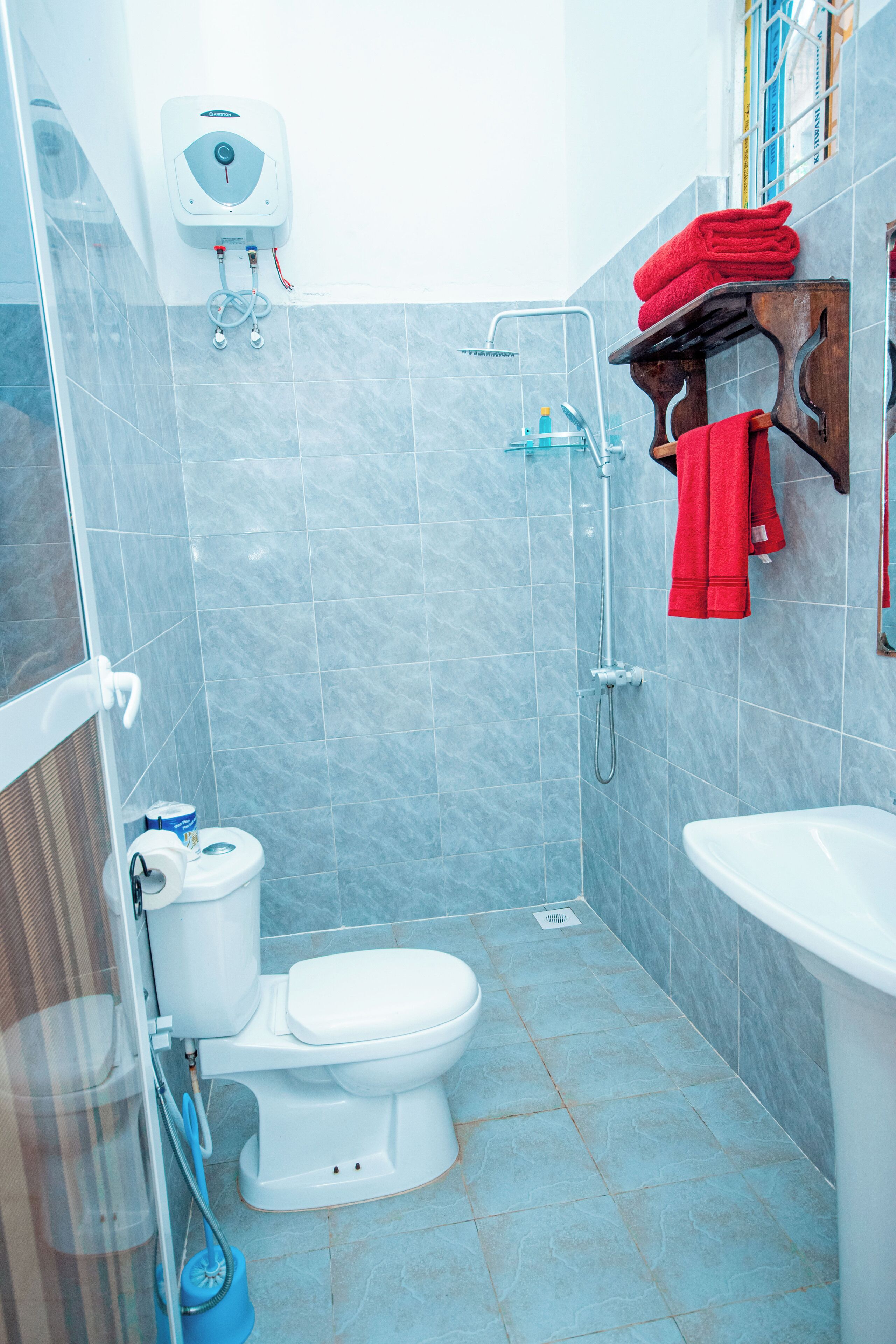 A bathroom with a toilet, shower, and sink.