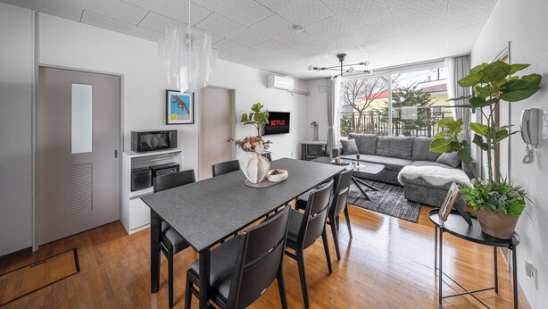 Un espacio de estar moderno con comedor, cocina y una zona de estar acogedora con sofá y mesa de centro.