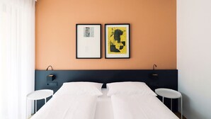 A hotel room with a double bed, two bedside tables, and two framed artworks on the wall. - Apartment Luis 3 - Alpstay (Naturns)