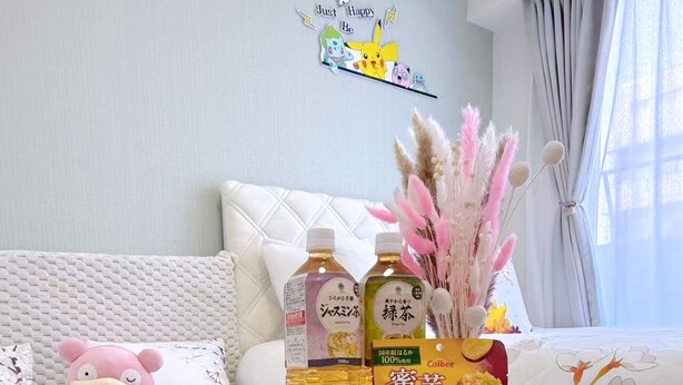 Une pièce chaleureuse avec un canapé blanc, une table ronde décorée d’un ours polaire et un mur orné d’une inscription qui dit « Soyez simplement heureux ».