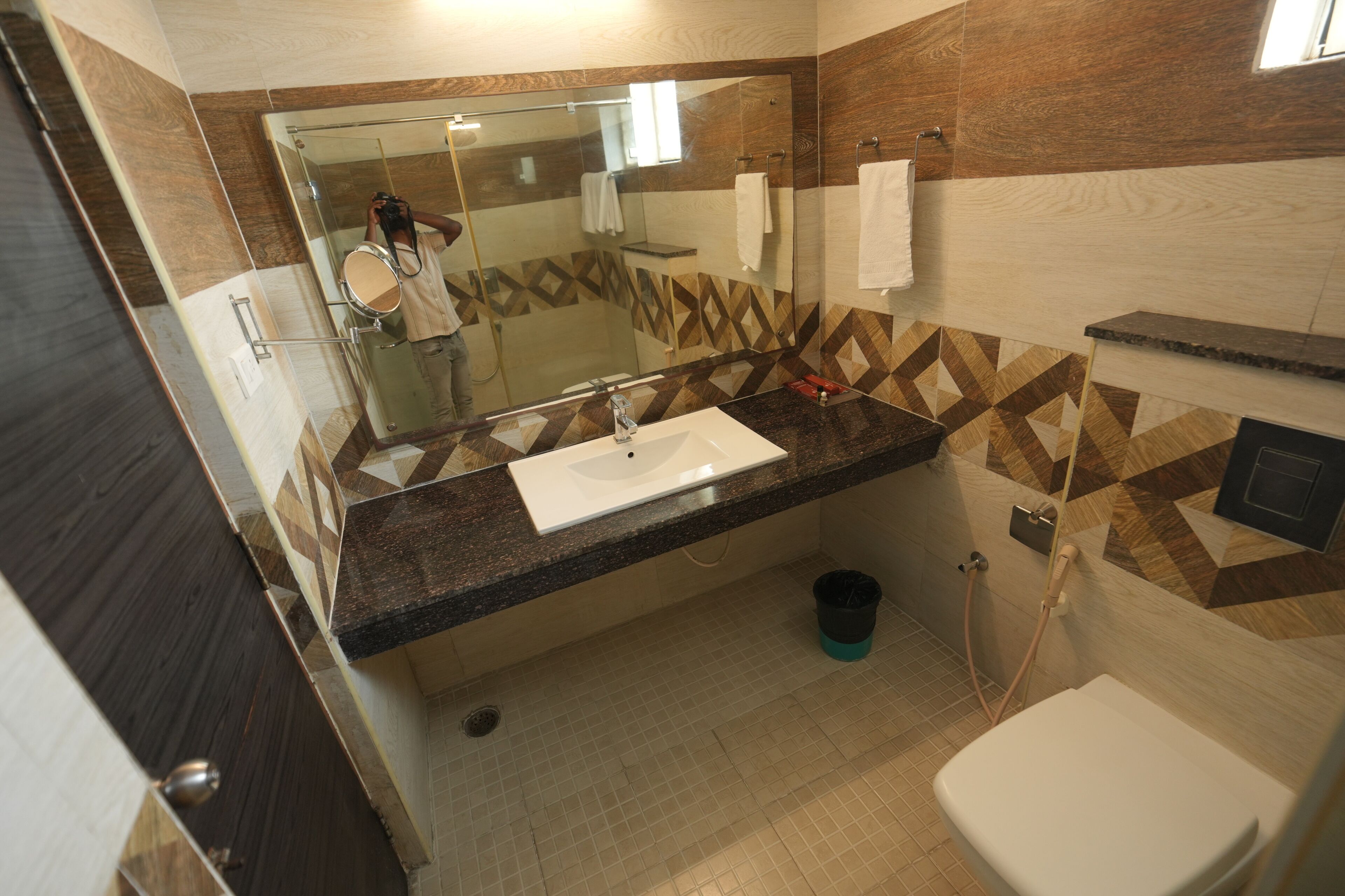 A bathroom with a glass shower enclosure, a sink with a mirror, and a toilet.