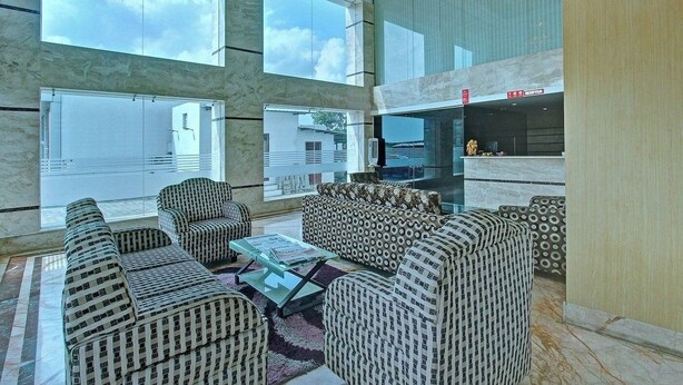 A spacious lobby with large windows, a reception desk, and seating arrangements. - Hotel Meridian Inn (Palayankottai)