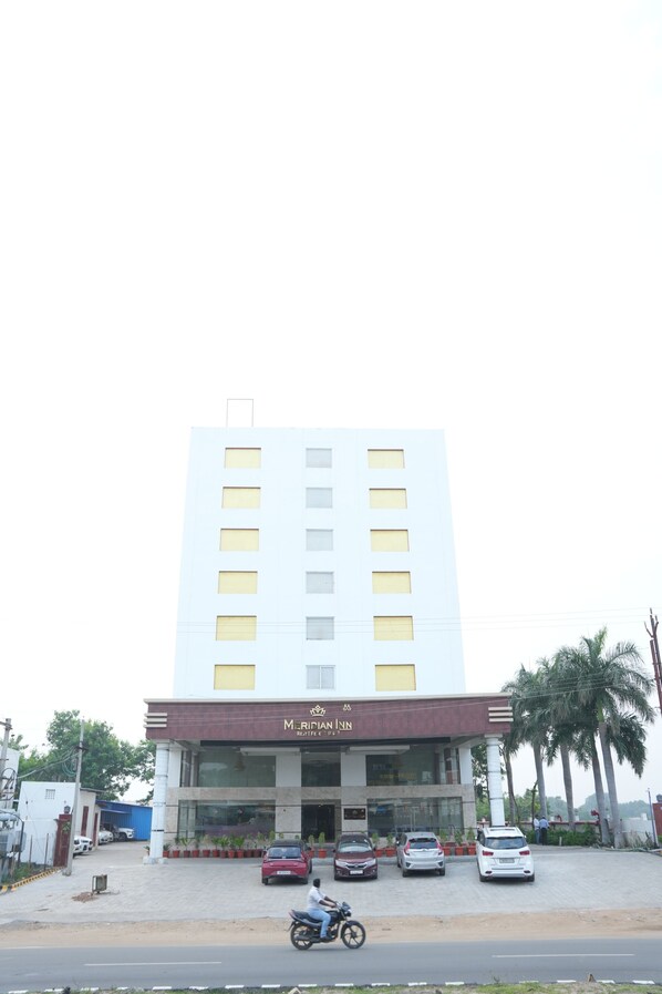A multi-story building with a prominent entrance and a sign that reads "M. RINIANH".