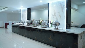 A modern reception area with a marble counter, multiple food service stations, and a clean, tiled floor. - Hotel Meridian Inn (Palayankottai)