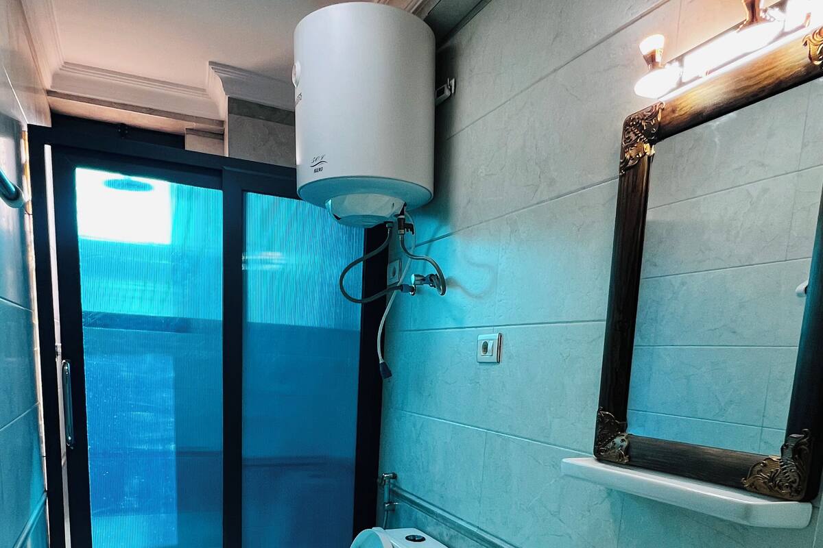 A bathroom with a toilet, sink, and mirror.