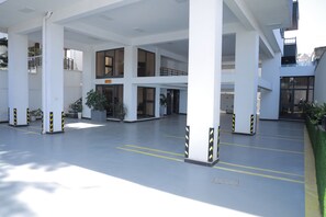 Ένας ευρύχωρος εσωτερικός χώρος με πολλά επίπεδα, μεγάλα παράθυρα και φυτά σε γλάστρες.