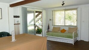 Ein Zimmer mit einem Bett, einem Tisch und einer Treppe, die zu einem Außenbereich führt.
