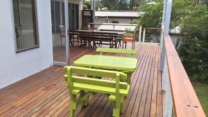Un patio al aire libre con suelo de madera y bancos verdes.