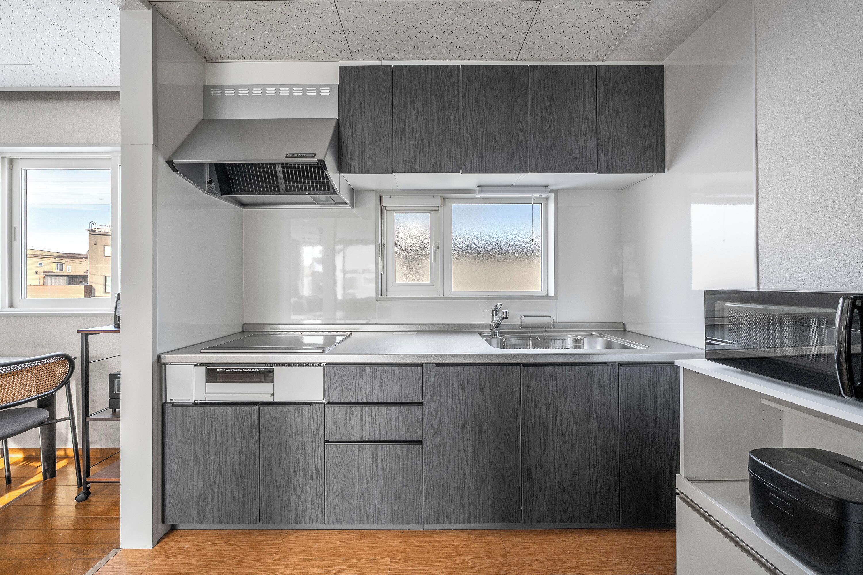 Een koelkast, een magnetron, een kookplaat, kookgerei, borden en bestek