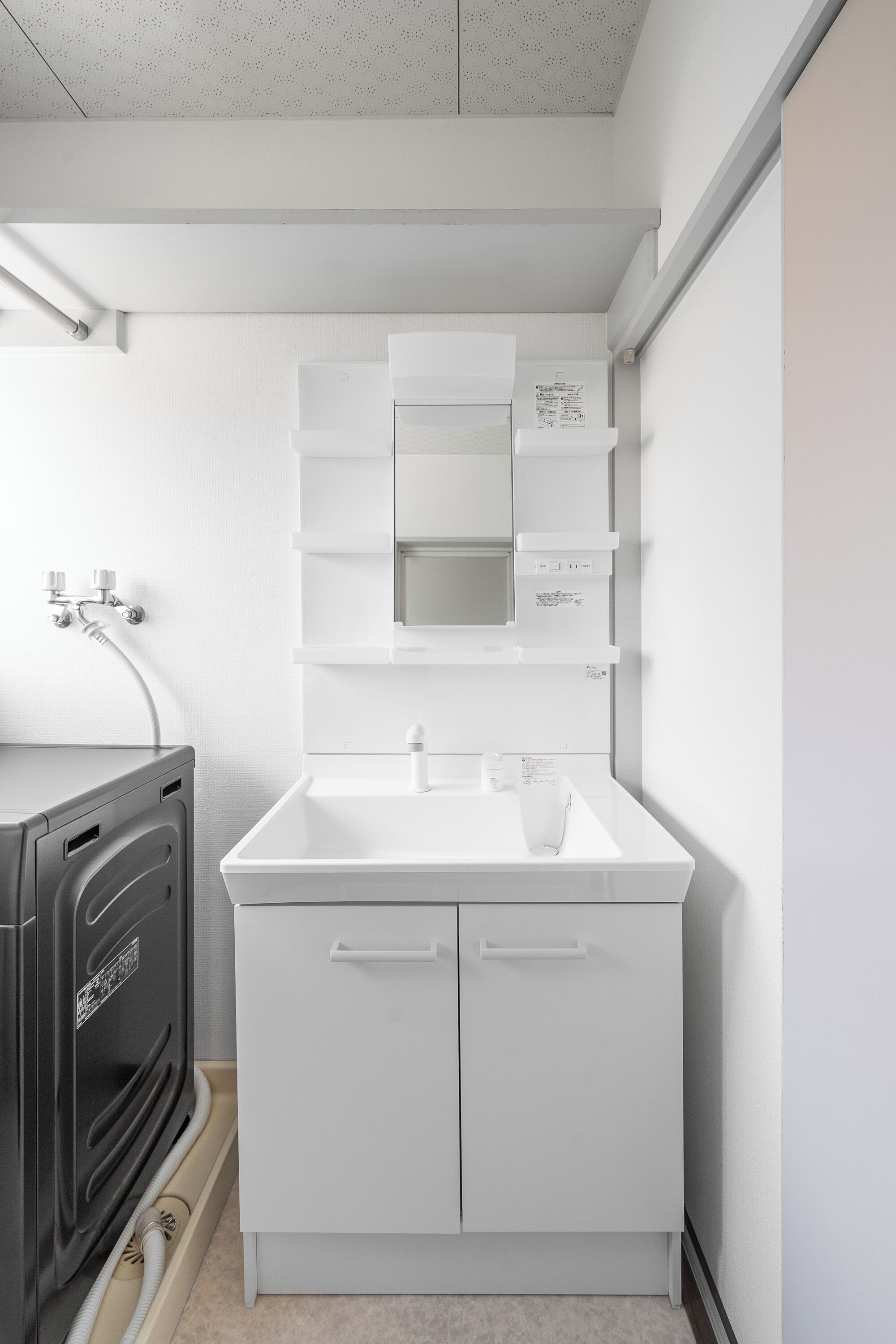 A compact kitchen with a white countertop, a sink, and a built-in oven.