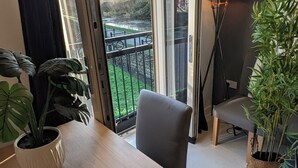 A balcony with a view of a construction site, a table with chairs, and a sign that reads "LEEDS I MILE". - Canal-side haven, short canal walk to city. Pet Friendly and parking! (Leeds)