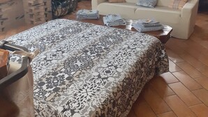 Un salon chaleureux avec une cheminée, un canapé et un tapis à motifs.