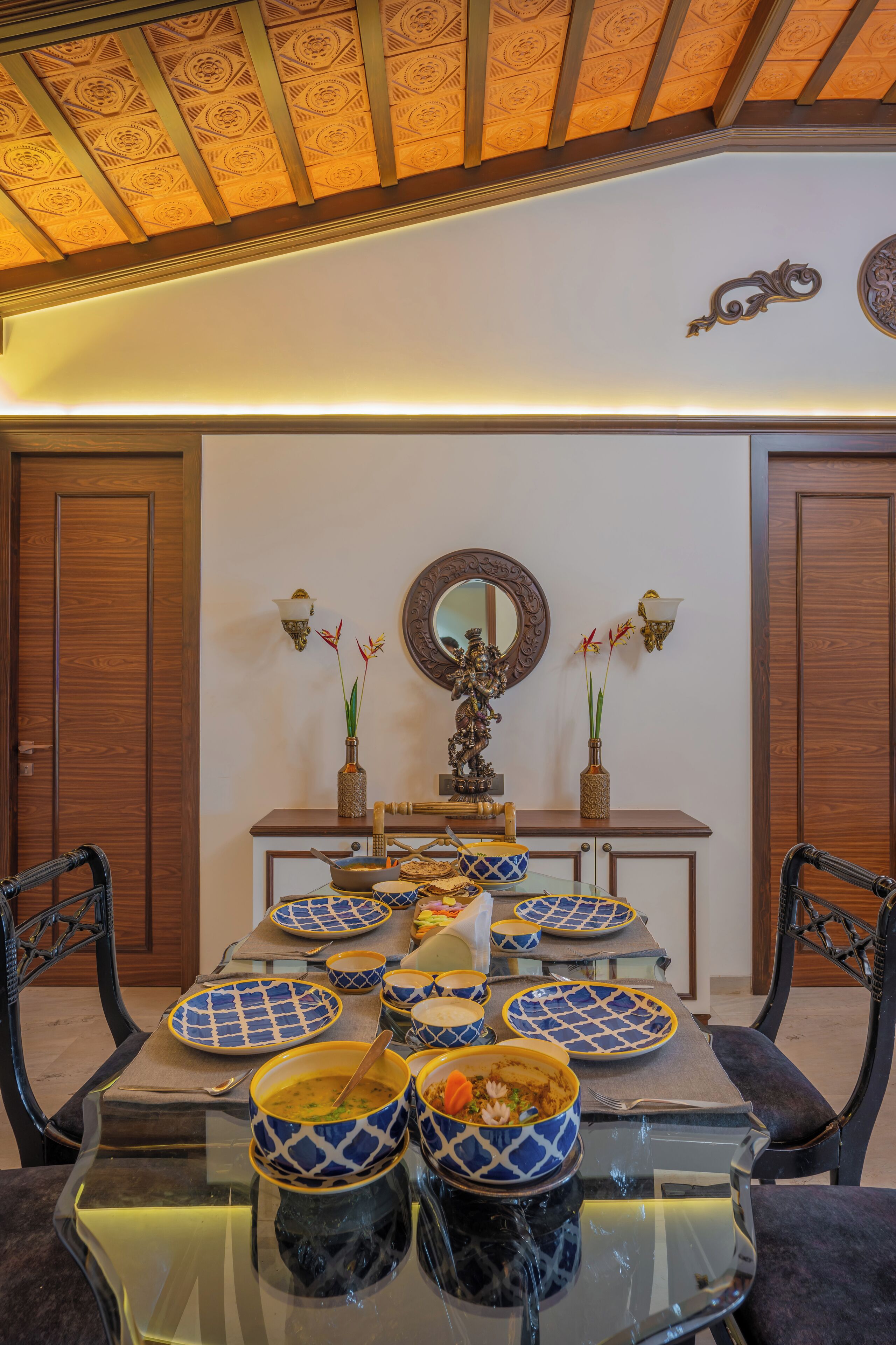 A dining area with a wooden table set for a meal, flanked by two chairs.