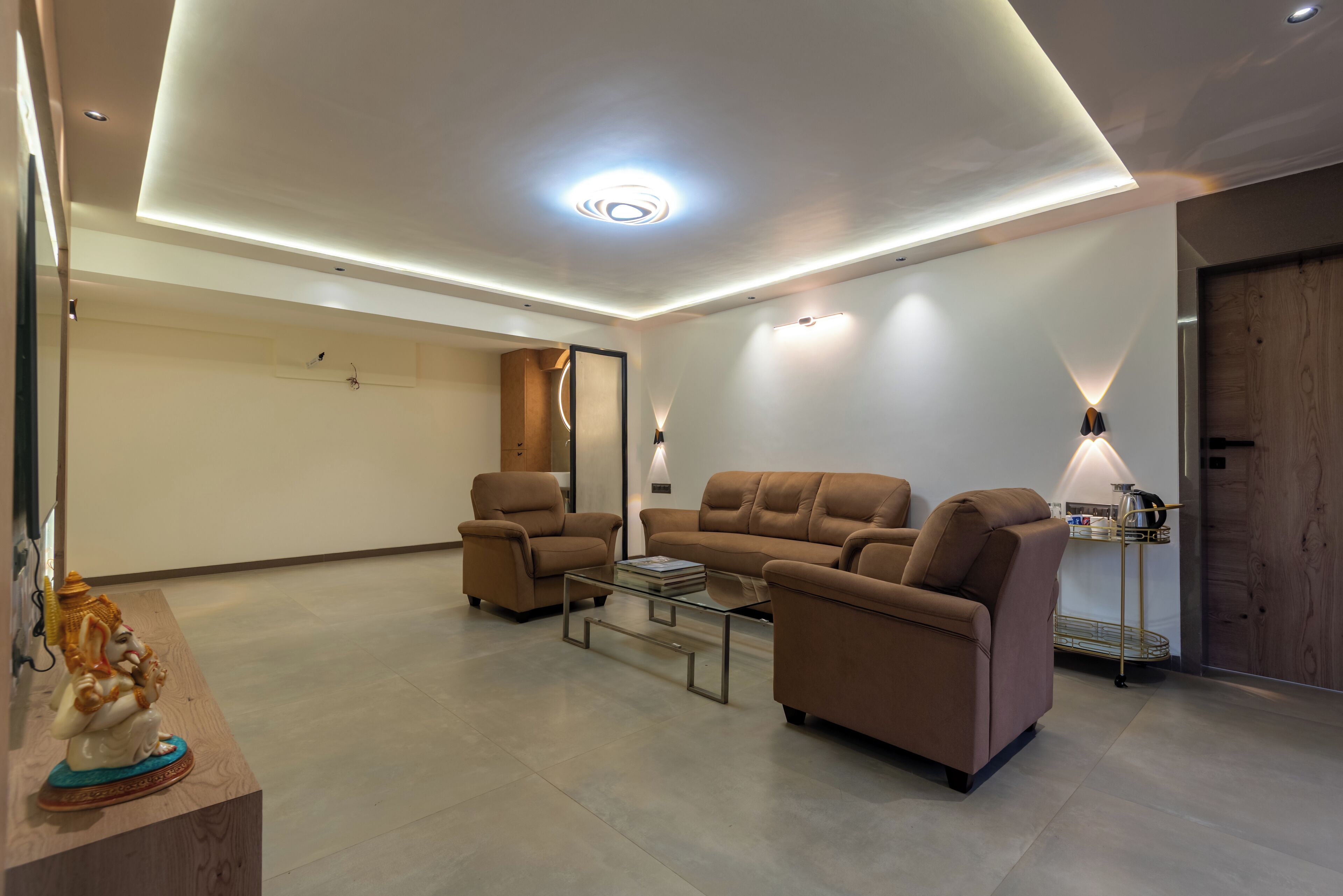 A modern living room with a sofa set, a coffee table, and a decorative statue.