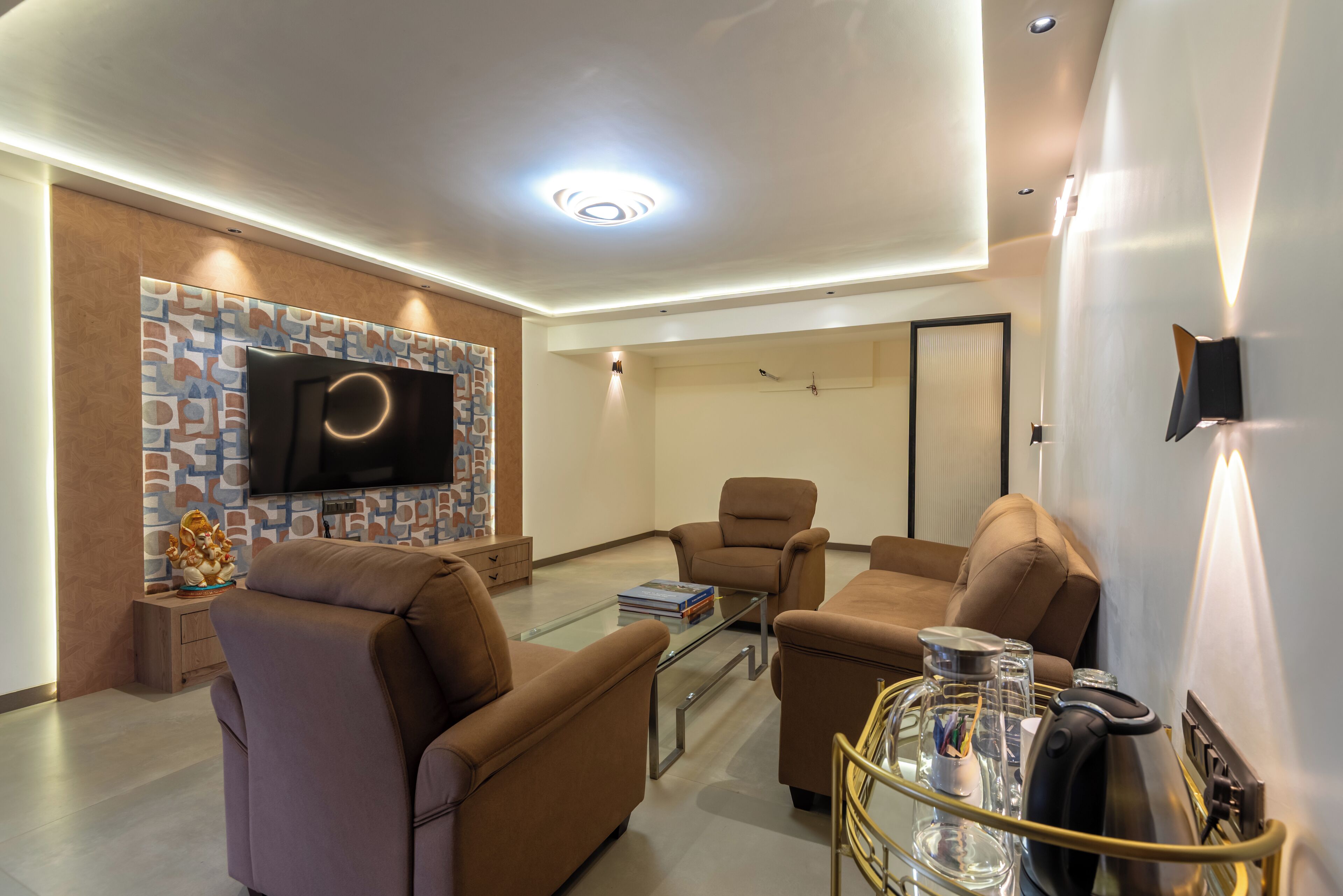 Un salon moderne doté d’un téléviseur à écran plat, de sièges confortables et d’une table basse en verre.