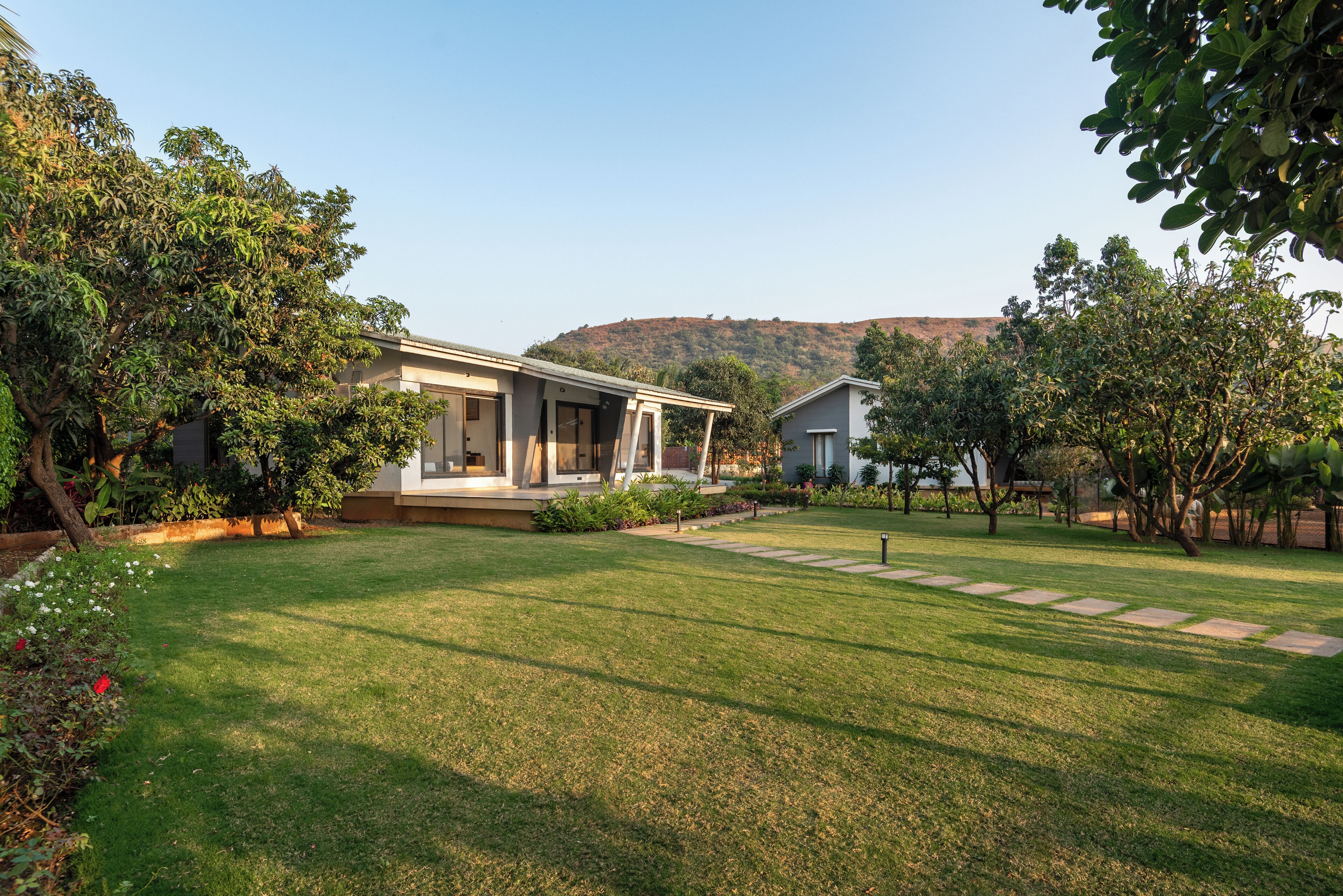 A modern house with a well-maintained lawn and a stone pathway leading to the entrance.