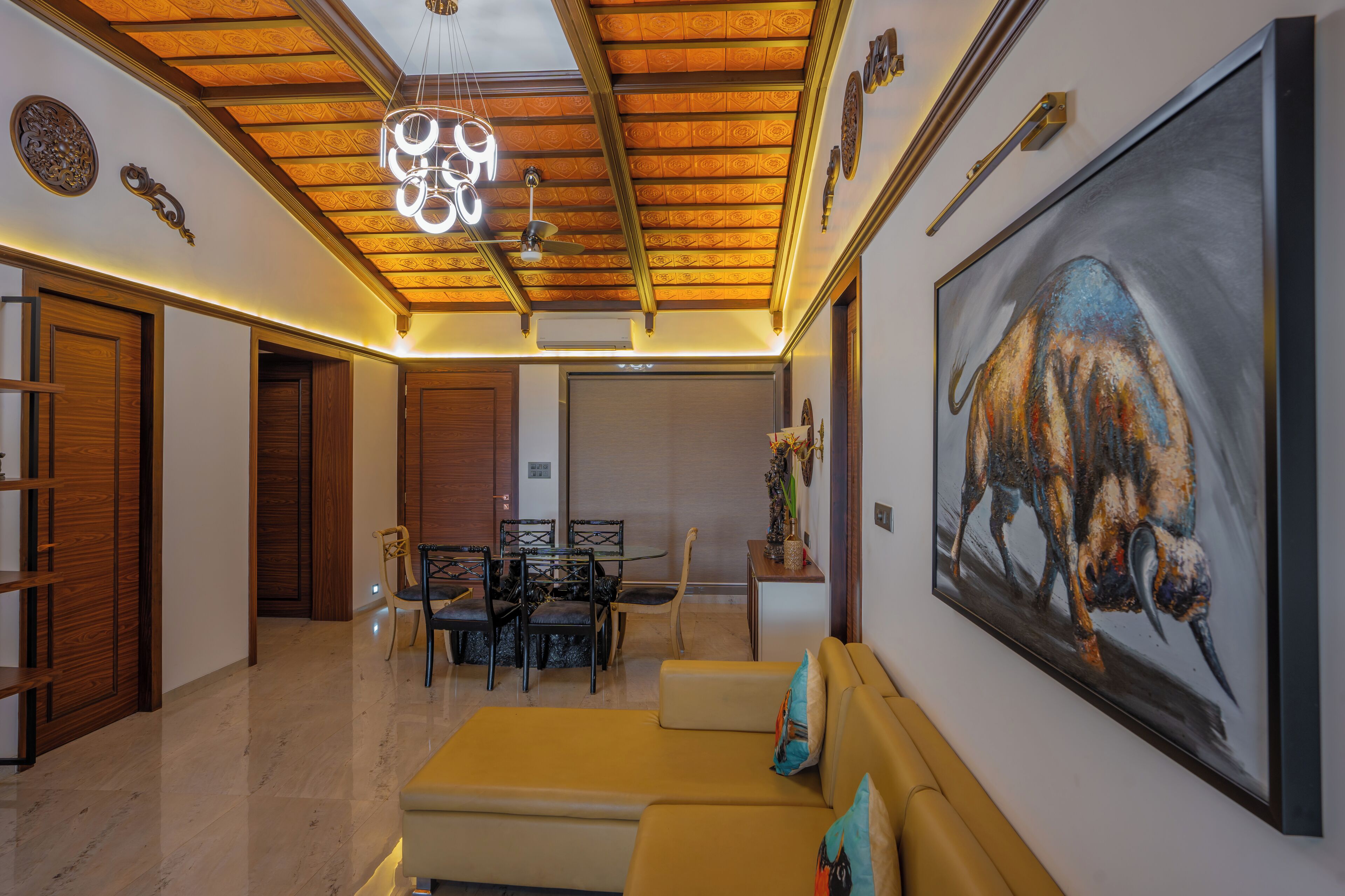 Una sala de estar moderna con techo de madera, un comedor y un cuadro grande de un bisonte.
