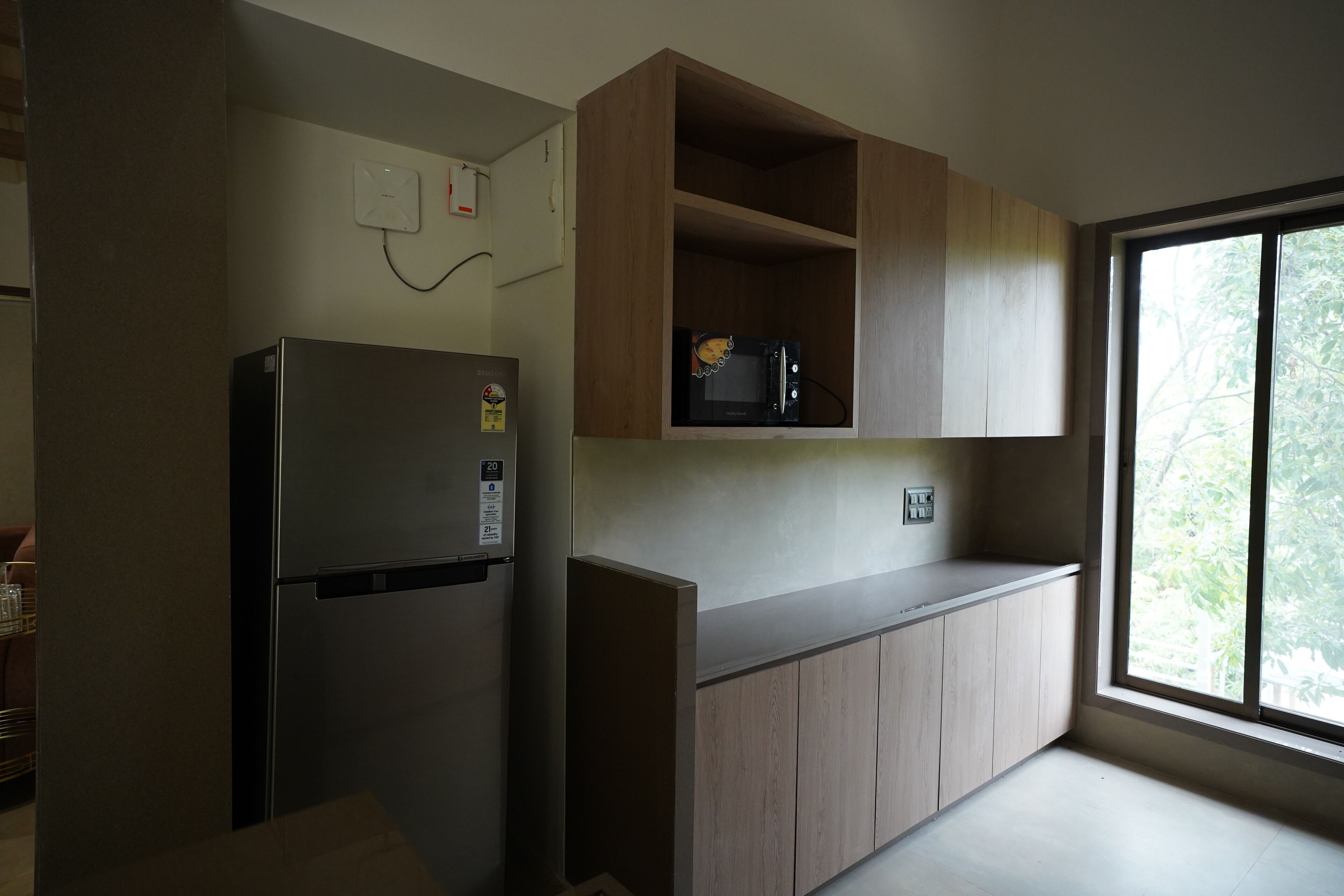A kitchen with a built-in refrigerator, wooden cabinets, and a window providing natural light.