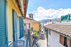 A narrow street with buildings on either side, a bell tower, and a clear sky. - Beautiful Holiday Home near Lake Maggiore (Verbania)