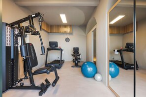 A home gym with a treadmill, exercise bike, and various weights. - Sea front villa with pool and tennis court - DiCasaInSicilia (Pozzillo)