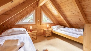 A cozy attic bedroom with two beds, wooden beams, and skylights. - Spacious chalet with wellness area (St. Georgen am Kreischberg)