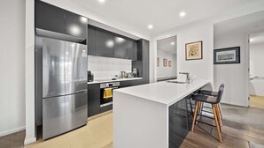 Een moderne keuken met een groot eiland, roestvrijstalen apparatuur en een minimalistisch design.
