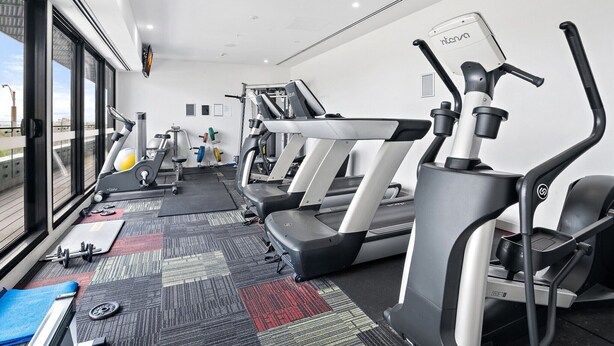 A gym with treadmills, ellipticals, and weight machines. - Renovated 2-Bed Apartment with Balcony (St Kilda)