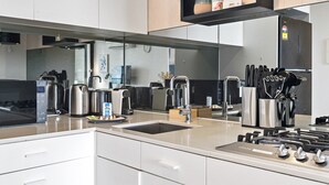 Una cucina moderna con elettrodomestici in acciaio inossidabile, un lavello e una macchina per il caffè.