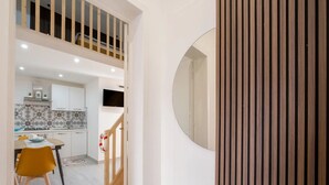 Un intérieur moderne comprenant une cuisine, un coin repas et un escalier menant à une mezzanine.