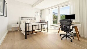 A modern bedroom with a bed, bedside table, and a desk with a chair. - Luxury villa 120m from beach & restaurants striking ocean & mountain view-by JGM (Cape Town)