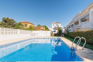 A swimming pool with a tiled edge, a metal ladder, and a white fence. - House with Barbecue Pool and Private Parking - Zona norte playa Gandía (Gandia)