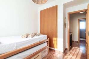A bedroom with a bed, a wooden wardrobe, and a bathroom visible through an open door. - House with Barbecue Pool and Private Parking - Zona norte playa Gandía (Gandia)