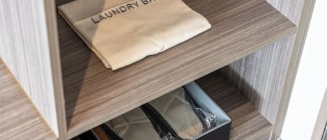 A neatly folded laundry bag labeled 'LAUNDRY BAG' on a wooden shelf.
