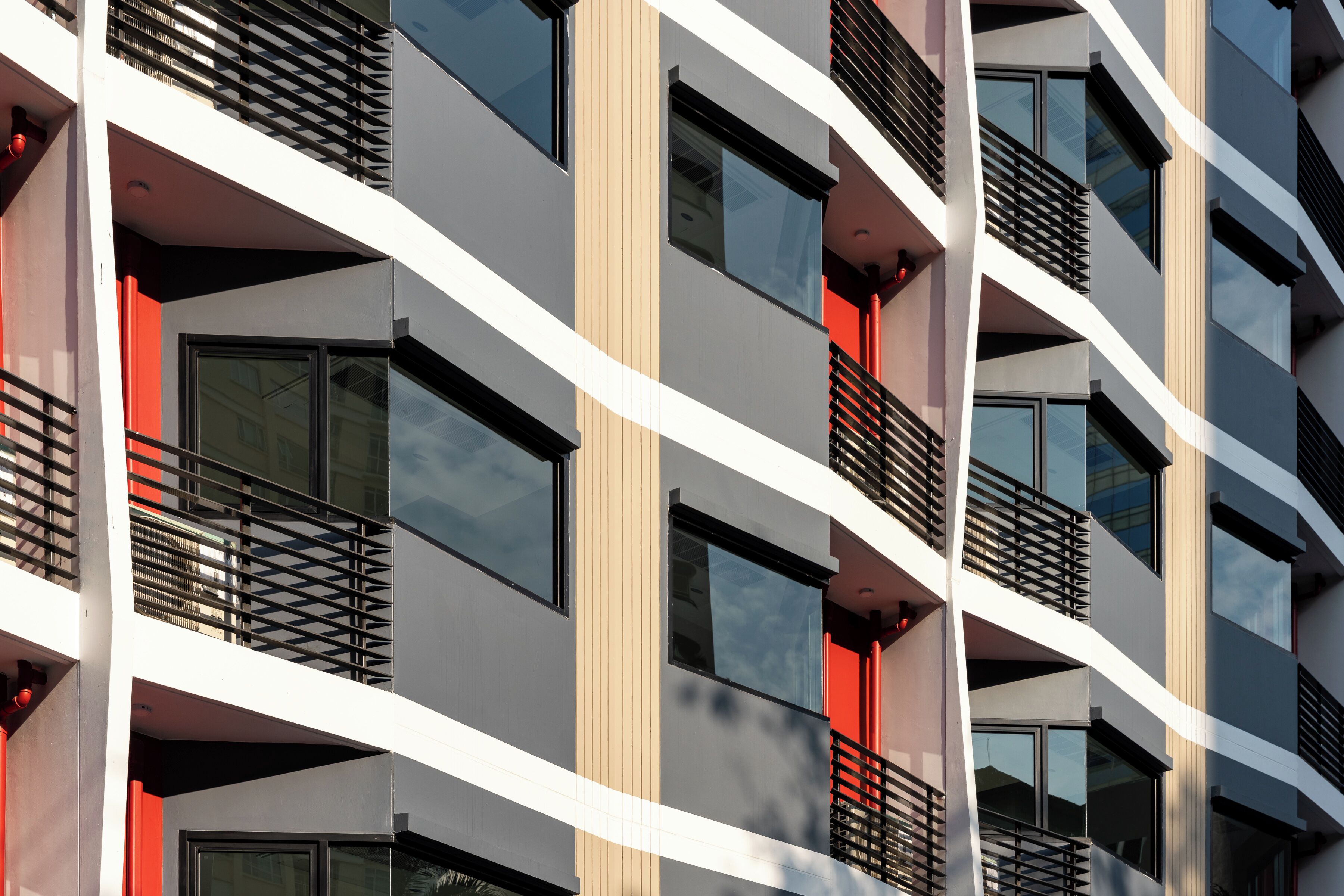 A multi-story building with balconies, large windows, and a modern architectural design.