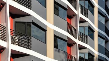 A multi-story building with balconies, large windows, and a modern architectural design.