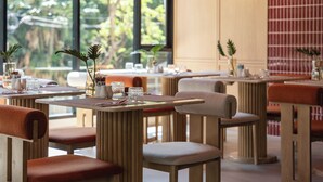Un restaurant avec des tables dressées, des chaises et des plantes en pot.
