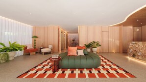 Une chambre à coucher moderne avec un canapé vert, un tapis à motifs et des murs en bois.