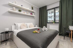 A modern bedroom with a bed, bedside table, and a window with curtains. - Cozy Apartment with balcony and Parking (Warszawa BIG)