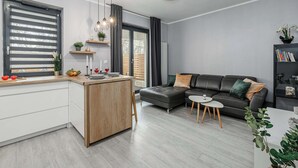Una sala de estar moderna con un sofá, una mesita y una cocina con mostrador.