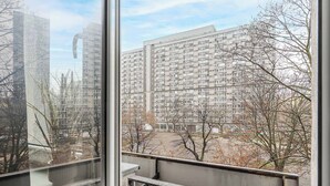 Ein Blick auf ein mehrstöckiges Wohngebäude mit Balkonen und einem Parkplatz im Vordergrund.