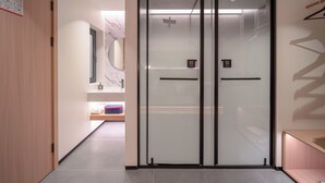 A hotel corridor with a wooden door, a glass elevator, and a marble wall. - She County Liuyue Qingshe Guesthouse  (Huangshan)