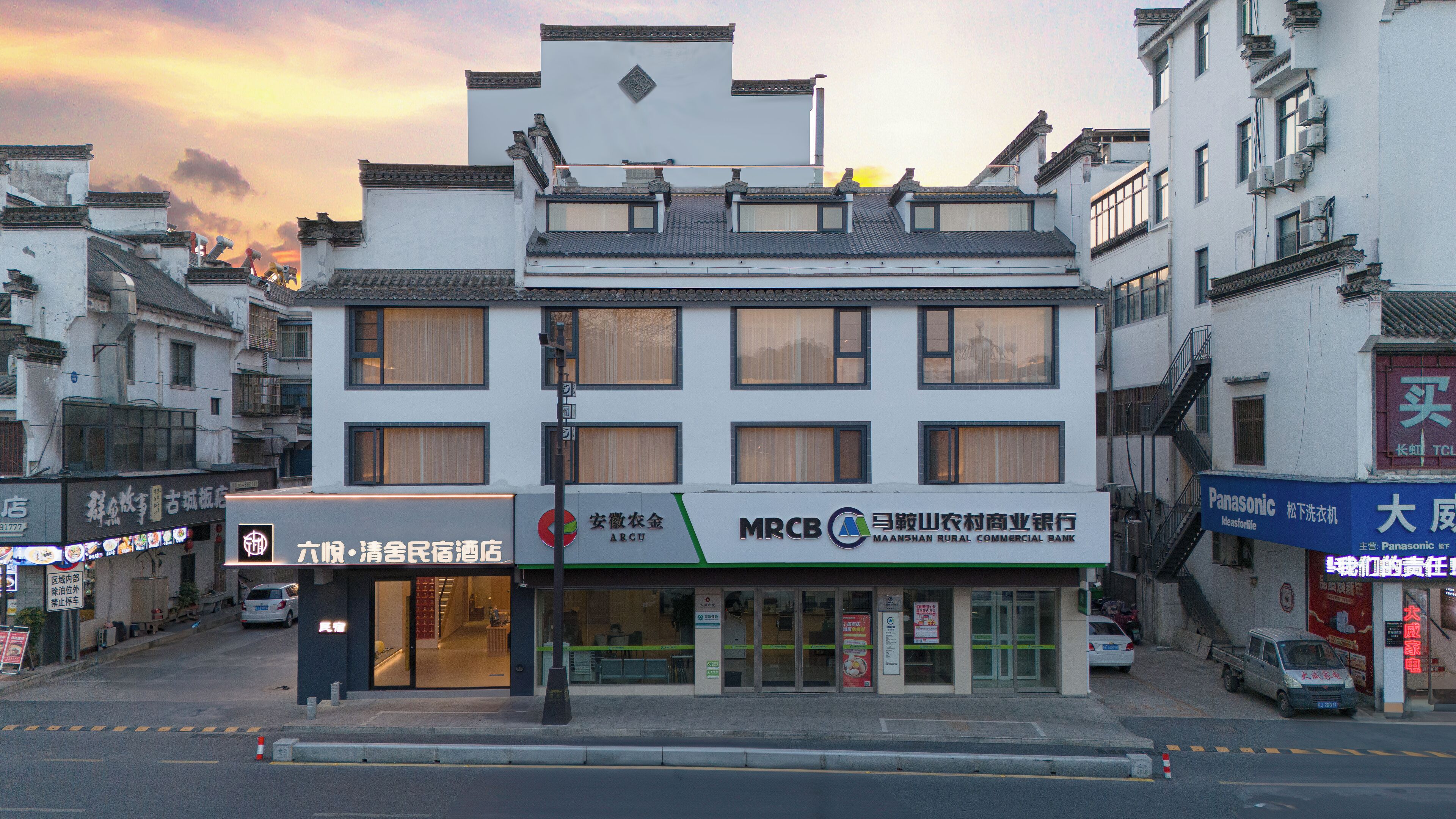A multi-story building with signage for a bank and a hotel.